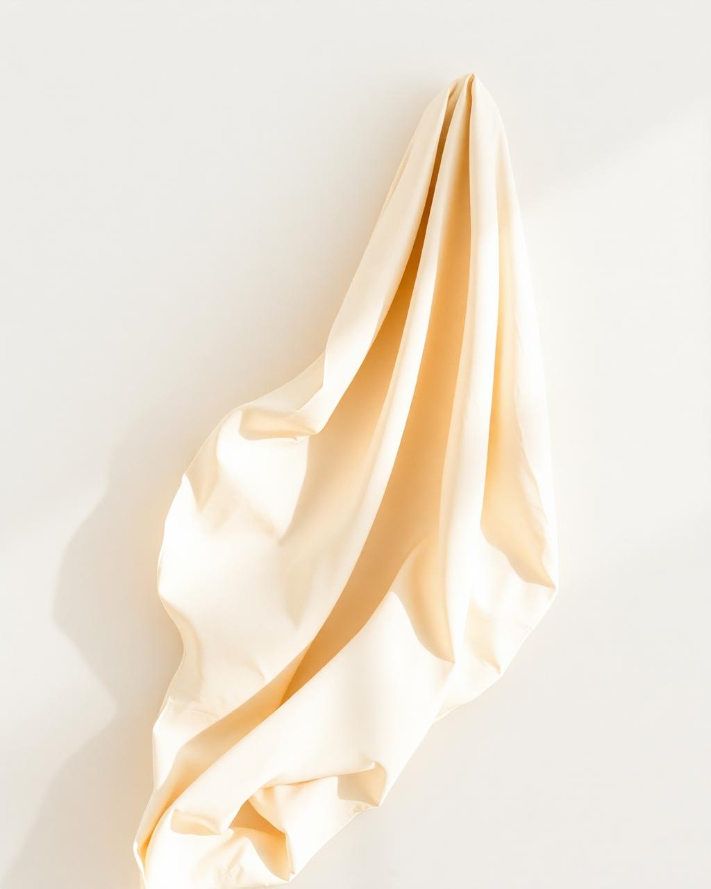 Soft cream fabric draped in quiet natural light